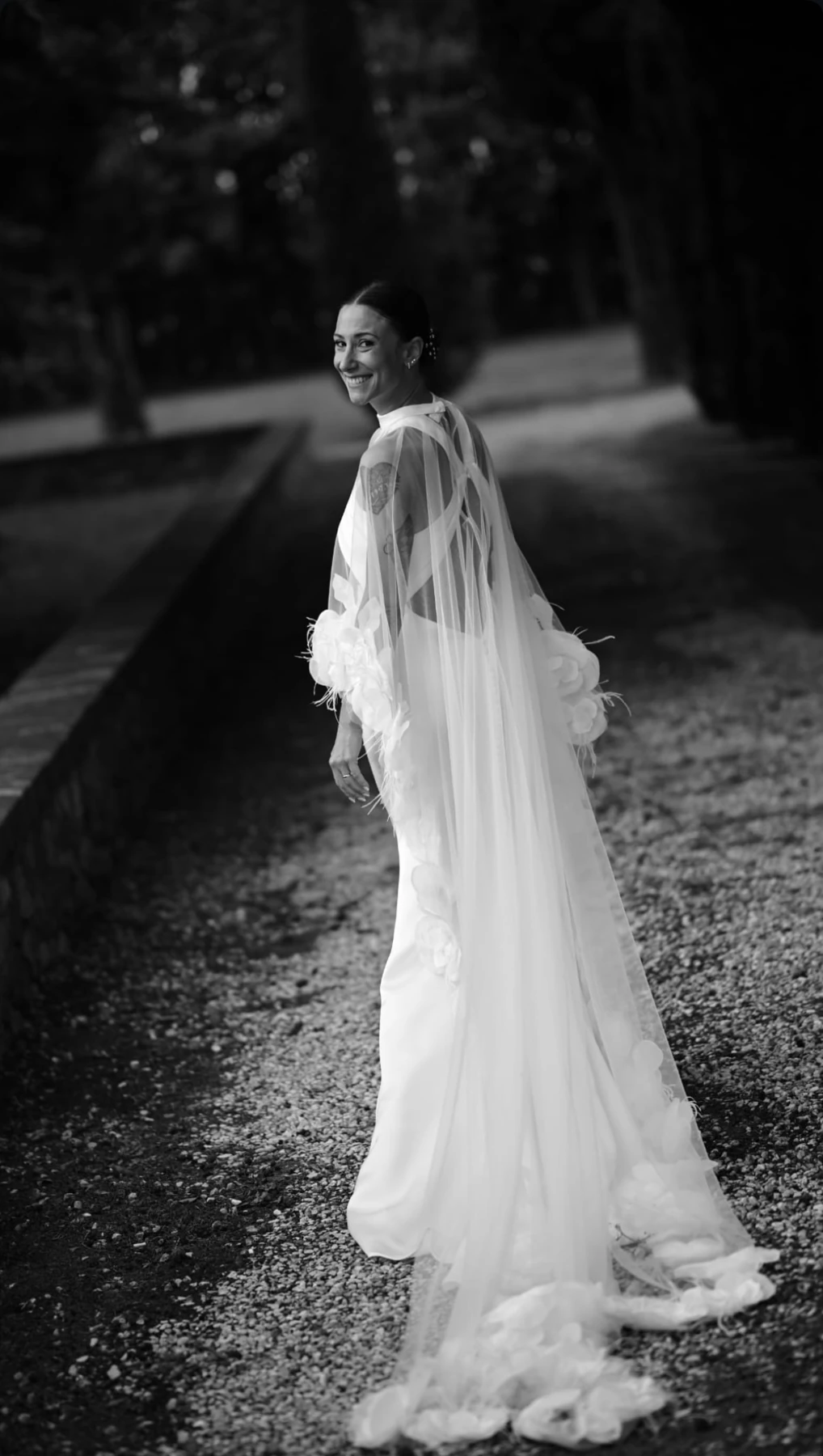 Fotografia in bianco e nero della sposa con velo all'aperto.