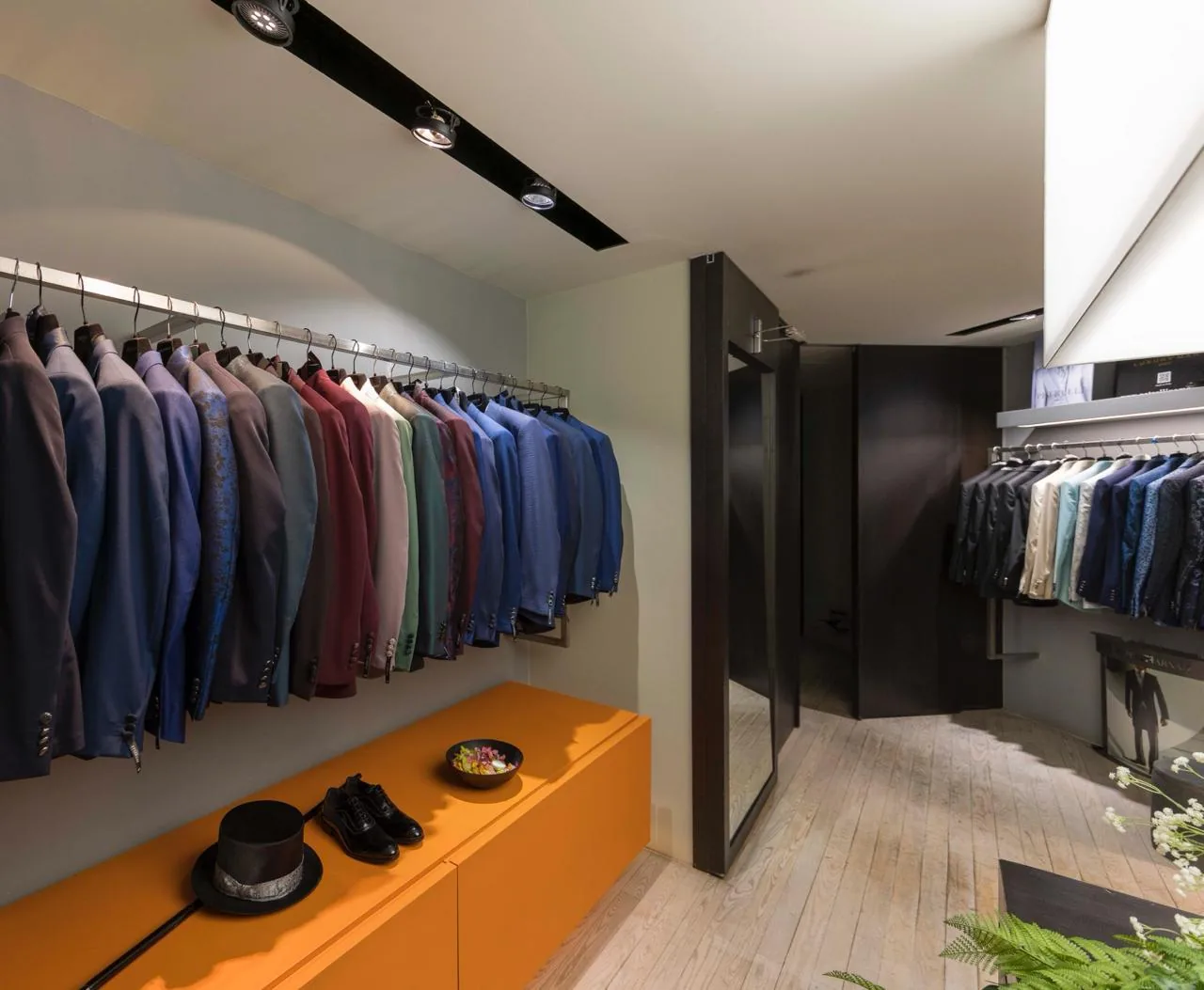 Abiti da uomo e accessori esposti nell’atelier.