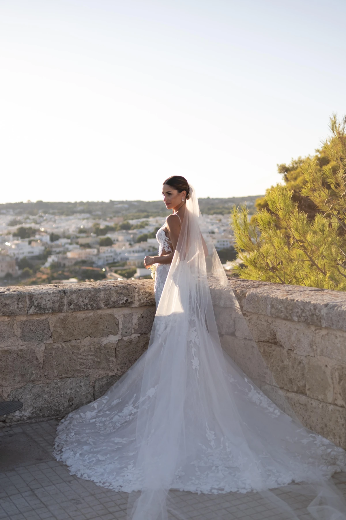 Sposa sulla terrazza in pietra con il panorama sullo sfondo.