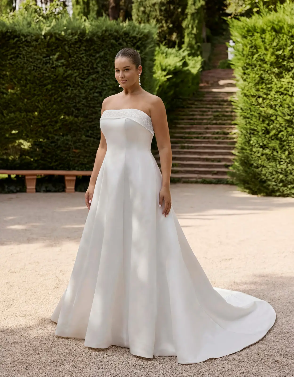 Abito da sposa senza spalline, con bordo ripiegato sul décolleté, gonna svasata e strascico.